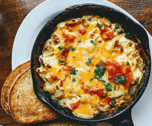 a cast iron skillet with a cheeseasserole on a plate at The Smarthill Sanctuary in Dalhousie