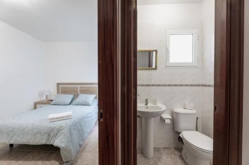 a bathroom with a bed and a sink and a toilet at Piso Leoncio Breña Alta in Breña Alta
