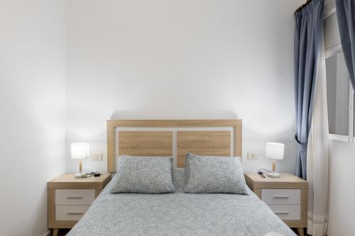a bedroom with a large bed with two night stands at Piso Leoncio Breña Alta in Breña Alta