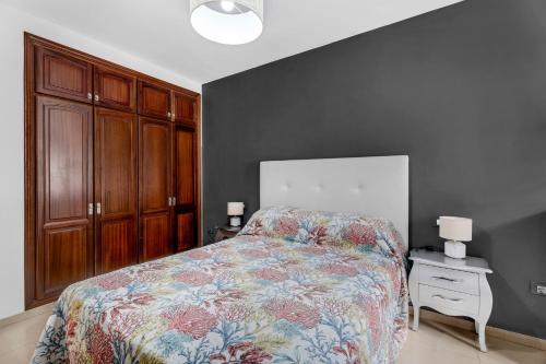 a bedroom with a bed and a table with a night stand at Bajamar en armonía in Bajamar