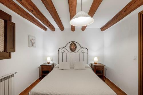 a bedroom with a white bed and two night stands at Masoveria De Vilanova in Sagás