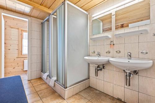 a bathroom with two sinks and a glass shower at L'Auberge de L'Ours in Vers L'Eglise