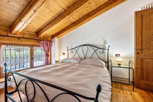 a bedroom with a bed and a wooden ceiling at Agritur Piazera Attico in Ronzo Chienis