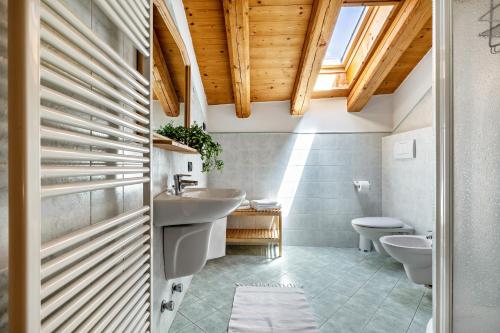 a bathroom with two toilets and a sink at Agritur Piazera Attico in Ronzo Chienis