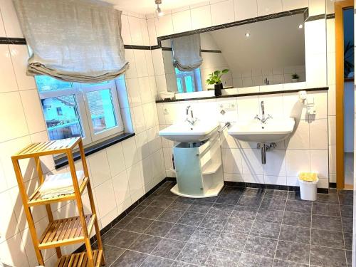 a bathroom with two sinks and a mirror at Osserblick Galerie in Lohberg