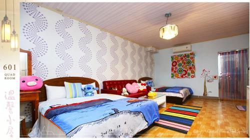una camera con due letti, un tavolo e una gonna da letto di Genial House a Jiaoxi