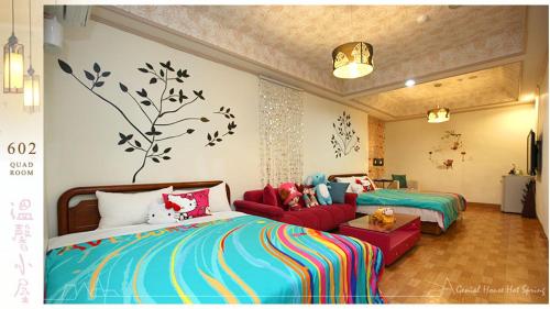 a bedroom with two beds and a red couch at Genial House in Jiaoxi