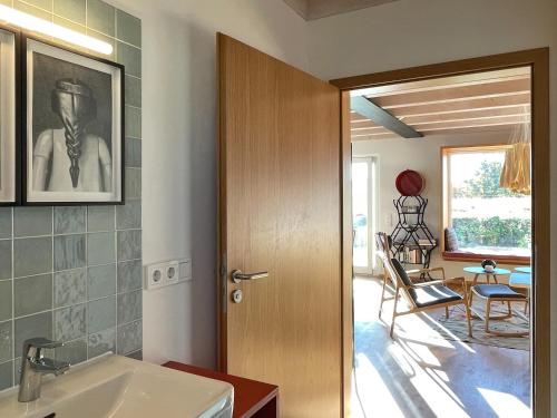 a bathroom with a door leading to a dining room at Ferienwohnung Waldmeisterzimmer in Sankt Peter