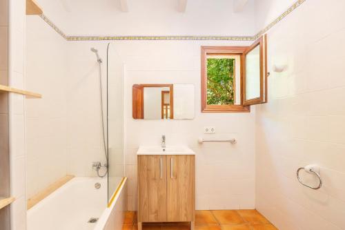 a bathroom with a sink and a tub and a mirror at Casita Rafal Roig in Maria de la Salut