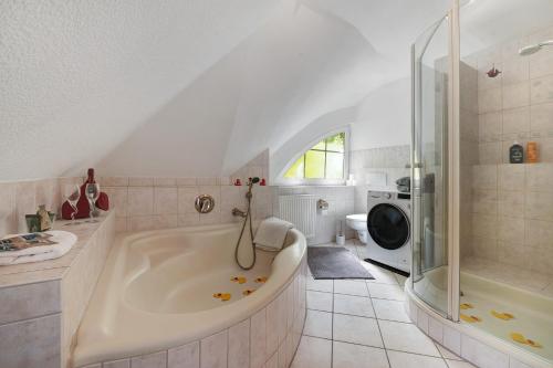a white bathroom with a tub and a shower at Ferienhaus im Grünen in Harsefeld
