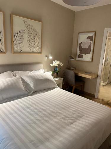 a bedroom with a large white bed and a desk at Villa Romantica Lake Idro in Bagolino