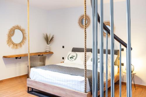 a bedroom with a swing bed and a staircase at Mont' Rock villas 2 in Posidhonía
