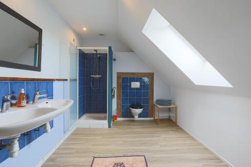 a bathroom with a sink and a shower and a toilet at Gite 8 personnes in Bégard