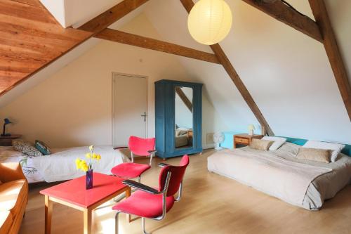 a bedroom with a bed and a table and chairs at Gite 8 personnes in Bégard