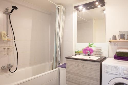 a bathroom with a sink and a washing machine at Appartement Evasion in Marseille