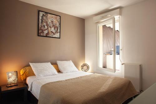 a bedroom with a white bed with a window at Appartement Evasion in Marseille