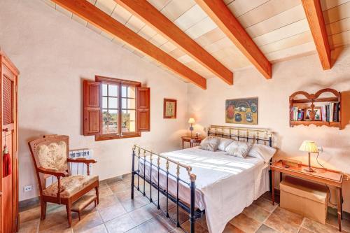 a bedroom with a bed and a desk and a chair at Son Garrot in Santanyi