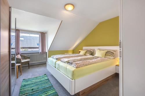 a bedroom with a bed with a green wall at Wohnung Hallighof in Honkenswarft