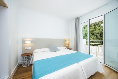 a bedroom with a bed and a large window at Apartament Massanet 1c in Canyamel