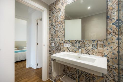 a bathroom with a sink and a mirror and a bed at Apartament Massanet 1c in Canyamel