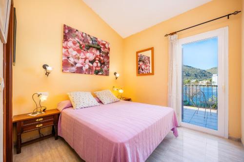 a bedroom with a bed and a large window at Llac D'alcudia in Port d'Alcudia