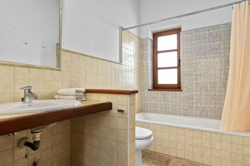 a bathroom with a sink and a toilet and a mirror at El Ferre in Nava