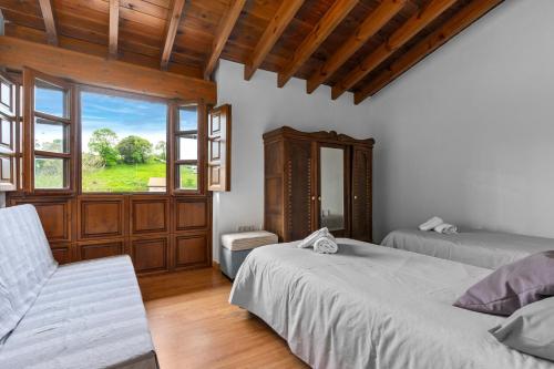 a bedroom with two beds and a window at El Ferre in Nava
