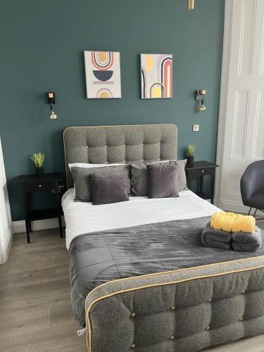 a bedroom with a large bed with blue walls at Seaside studio apartment in Weston-super-Mare