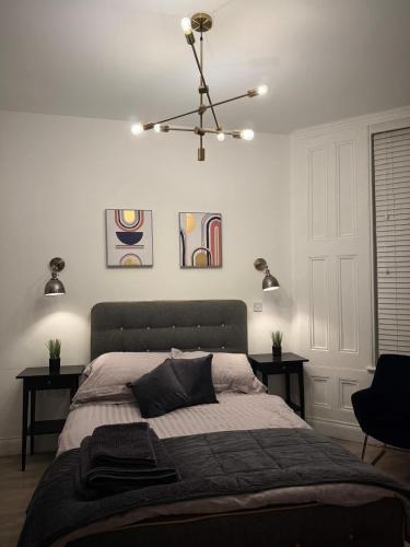 a bedroom with a large bed with two tables at Seaside studio apartment in Weston-super-Mare