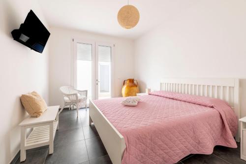 a bedroom with a pink bed and a tv at Villa Venza , Salento in Otranto
