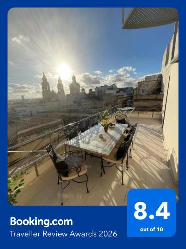 a table and chairs on a balcony with a view at Sliema Cozy Townhouse with Rooftop View, Prime Spot in Sliema