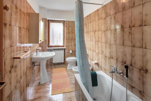 a bathroom with a sink and a toilet and a tub at Appartamenti Adriano Minotto in Falcade