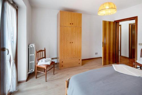 a bedroom with a bed and a wooden cabinet at Appartamenti Adriano Minotto in Falcade