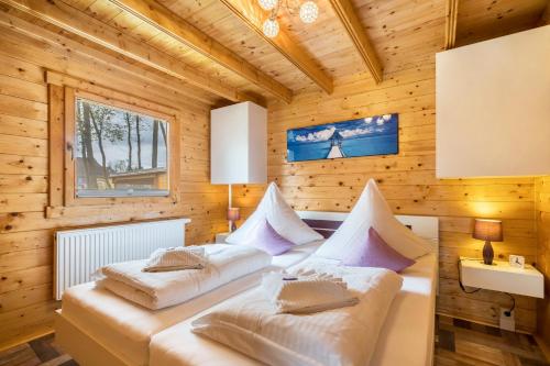 two beds in a room with wooden walls at Ferienhaus 4 Familie Täubert in Klein Uhyst
