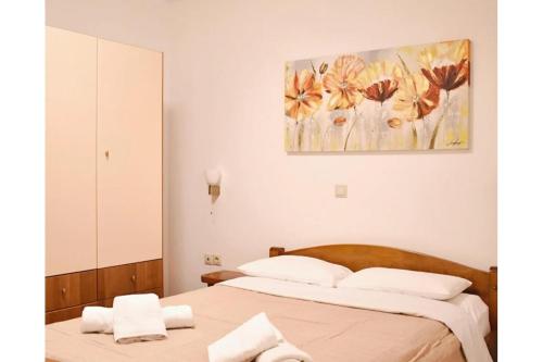 a bedroom with two beds and a painting on the wall at Manolika Studio 3 in Kithnos