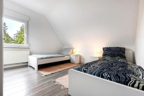 a white bedroom with a bed and a window at Haus am Garten in Brunkensen