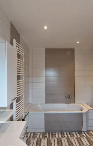 a white bathroom with a tub in a room at Müritz - Domizil in Waren
