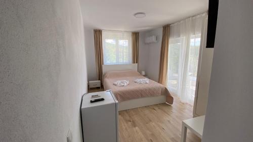a small bedroom with a bed and a refrigerator at Casa NICORAD Apartamente in Pucioasa