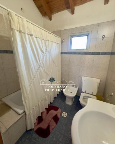 a bathroom with a toilet and a shower curtain at Costa Azul 4 in Villa Pehuenia