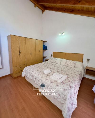 a bedroom with a bed and a wooden floor at Costa Azul 4 in Villa Pehuenia
