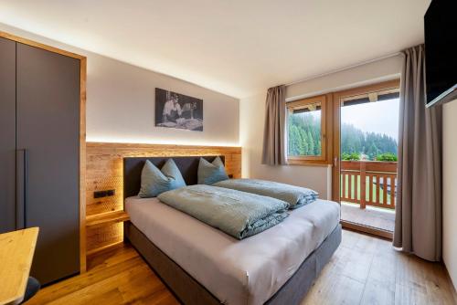 a bedroom with a bed and a balcony at Oberhaushof in Santa Valpurga