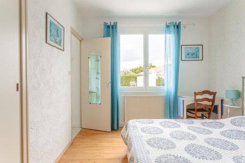 a bedroom with a bed and a table and a window at Maison d'hôtes Le Grillon in La Brée-les-Bains