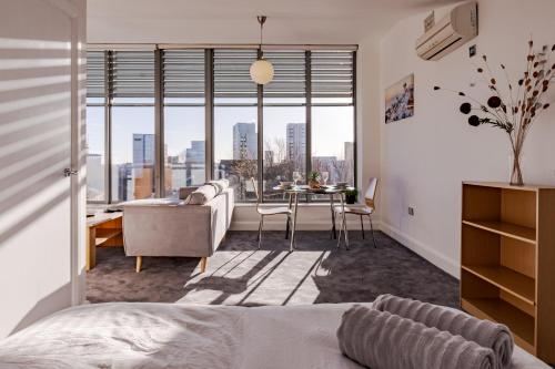 a bedroom with a bed and a dining room with a view at Penthouse Split Level 5 min walk to City Centre in Coventry