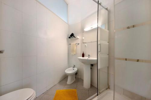 a white bathroom with a toilet and a sink at A Casa Formosa in Porto