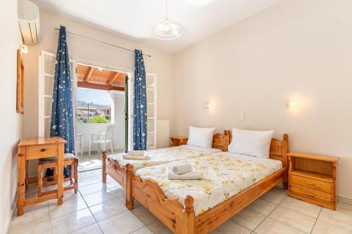 ein Schlafzimmer mit einem großen Bett und einem Fenster in der Unterkunft Olivea Apt 4 in Acharavi