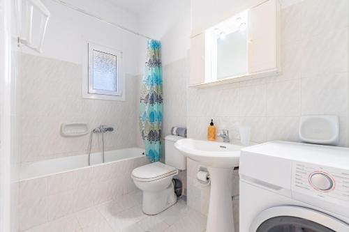 ein Badezimmer mit Toilette, Waschbecken und Waschmaschine in der Unterkunft Olivea Apt 4 in Acharavi