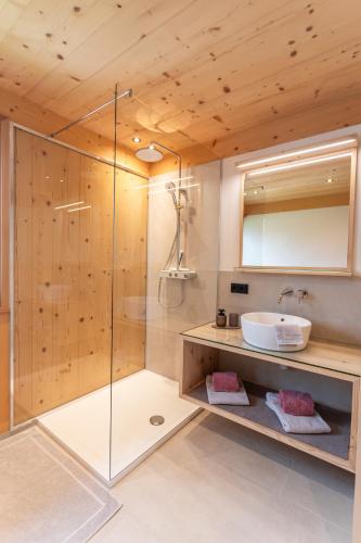a bathroom with a shower with a sink and a mirror at Haus Hoalp in Au