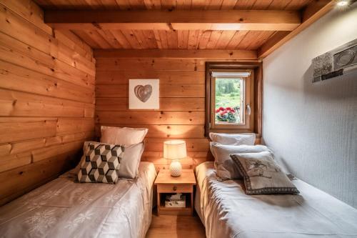 a room with two beds in a log cabin at Appartement chalet - Le Caribou in Morzine