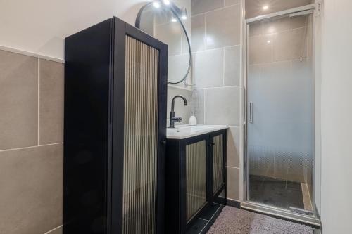 a bathroom with a sink and a shower at Le Jardin des Oiseaux in Clans