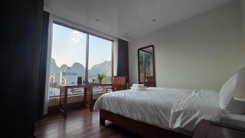 a bedroom with a bed and a large window at Viet Son Lam Hotel in Dồng Văn